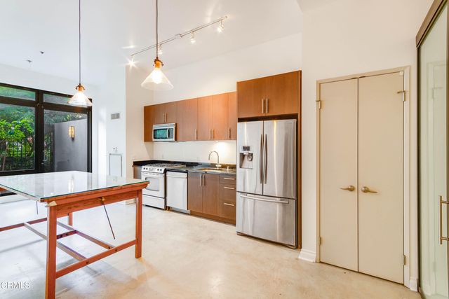 a kitchen with stainless steel appliances granite countertop a refrigerator a stove a sink and a refrigerator