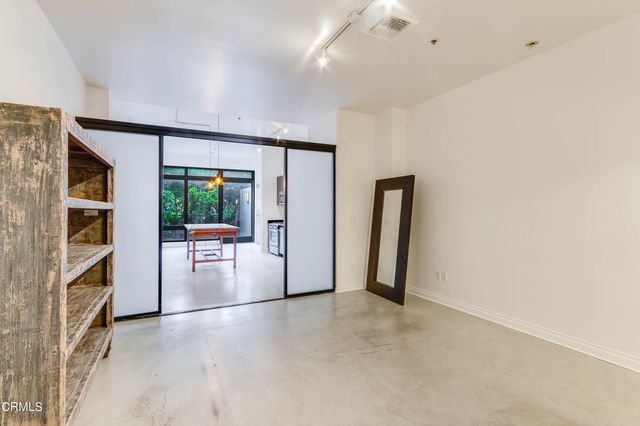 an empty room with fireplace and natural light