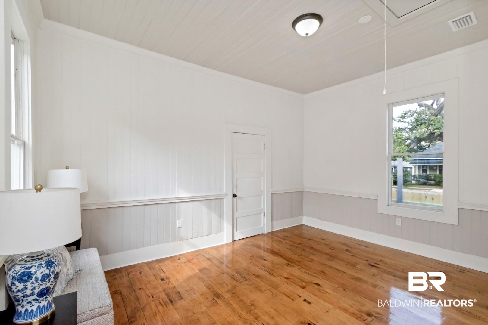 352 Marine Street Mobile, AL 36604 - Photo 10 of 20 Unfurnished room featuring hardwood / wood-style floors, attic access, wood walls, wainscoting, and crown molding