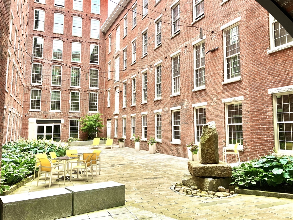 130 John Street, Unit G01 Lowell, MA 01852 - Photo 23 of 40 a view of a building with a yard