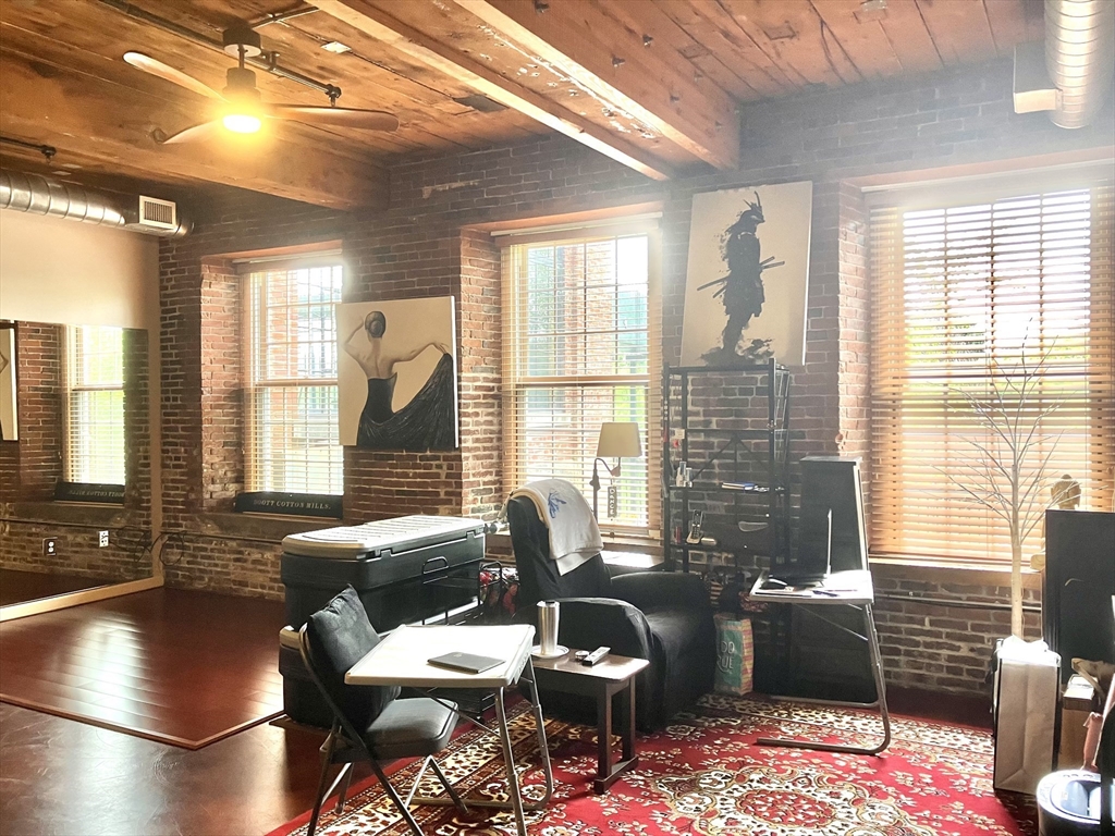 130 John Street, Unit G01 Lowell, MA 01852 - Photo 33 of 40 a living room with furniture and a floor to ceiling window