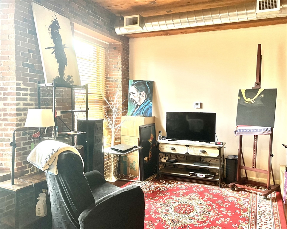 130 John Street, Unit G01 Lowell, MA 01852 - Photo 35 of 40 a living room with furniture and a flat screen tv