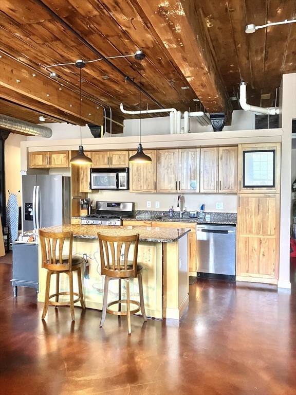 130 John Street, Unit G01 Lowell, MA 01852 - Photo 36 of 40 a large white kitchen with lots of counter space and a dining table