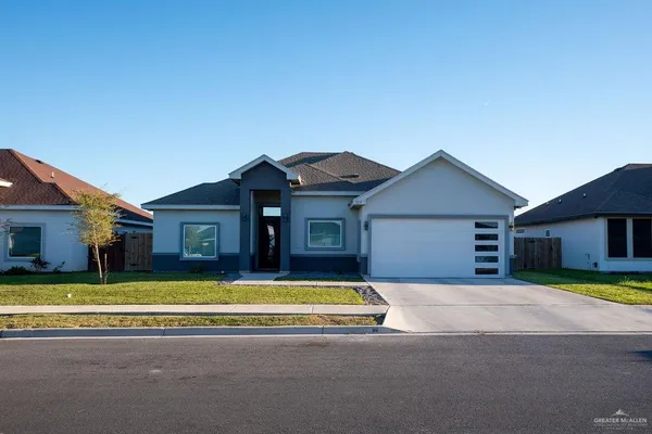 a view of a house with a big yard and large trees