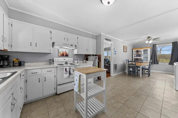 a kitchen with white cabinets and window