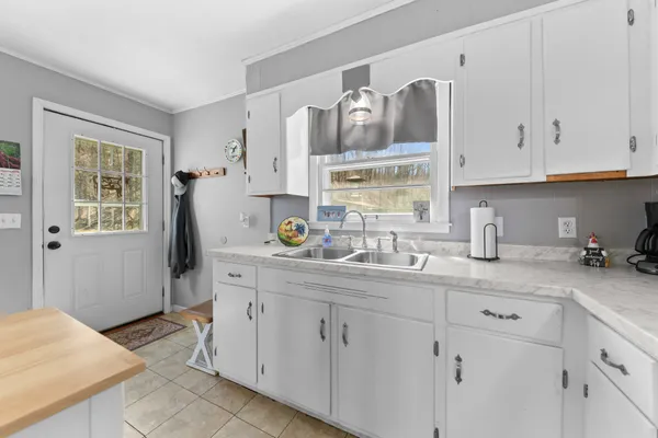 a kitchen with stainless steel appliances a refrigerator sink cabinets and wooden floor
