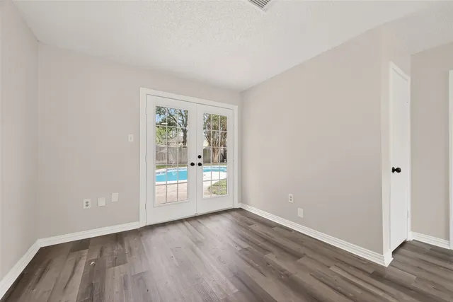 an empty room with wooden floor and ceiling fan