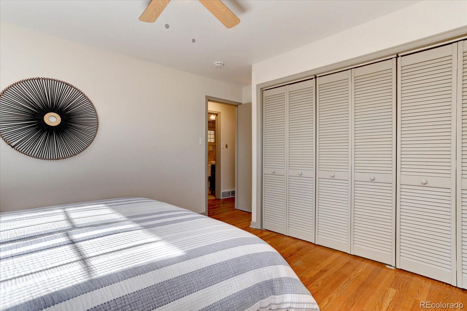 7141 Raritan Street Denver, CO 80221 - Photo 11 of 29 a bedroom with a bed and a chandelier