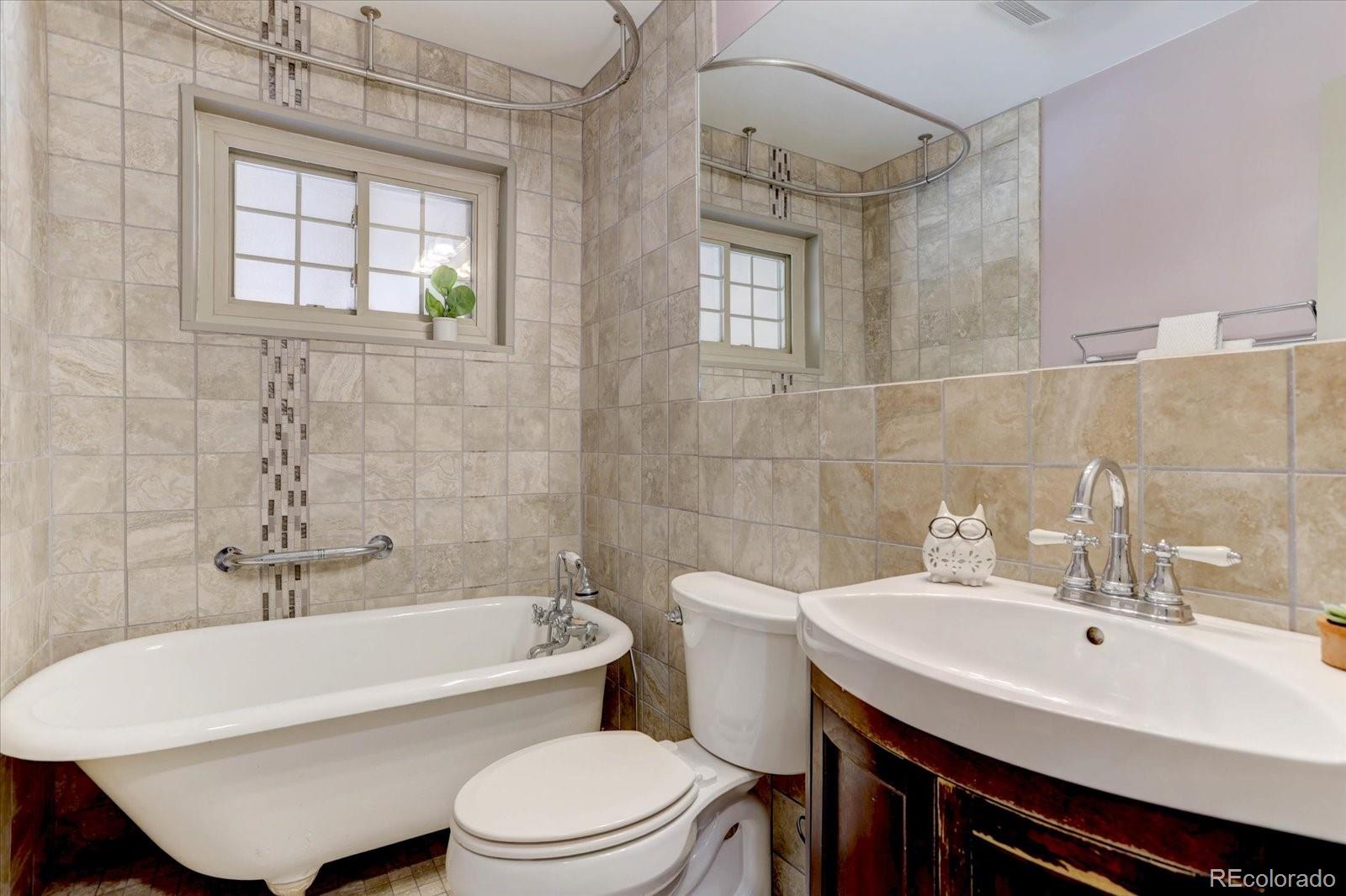 7141 Raritan Street Denver, CO 80221 - Photo 12 of 29 a bathroom with a sink toilet a mirror and tub