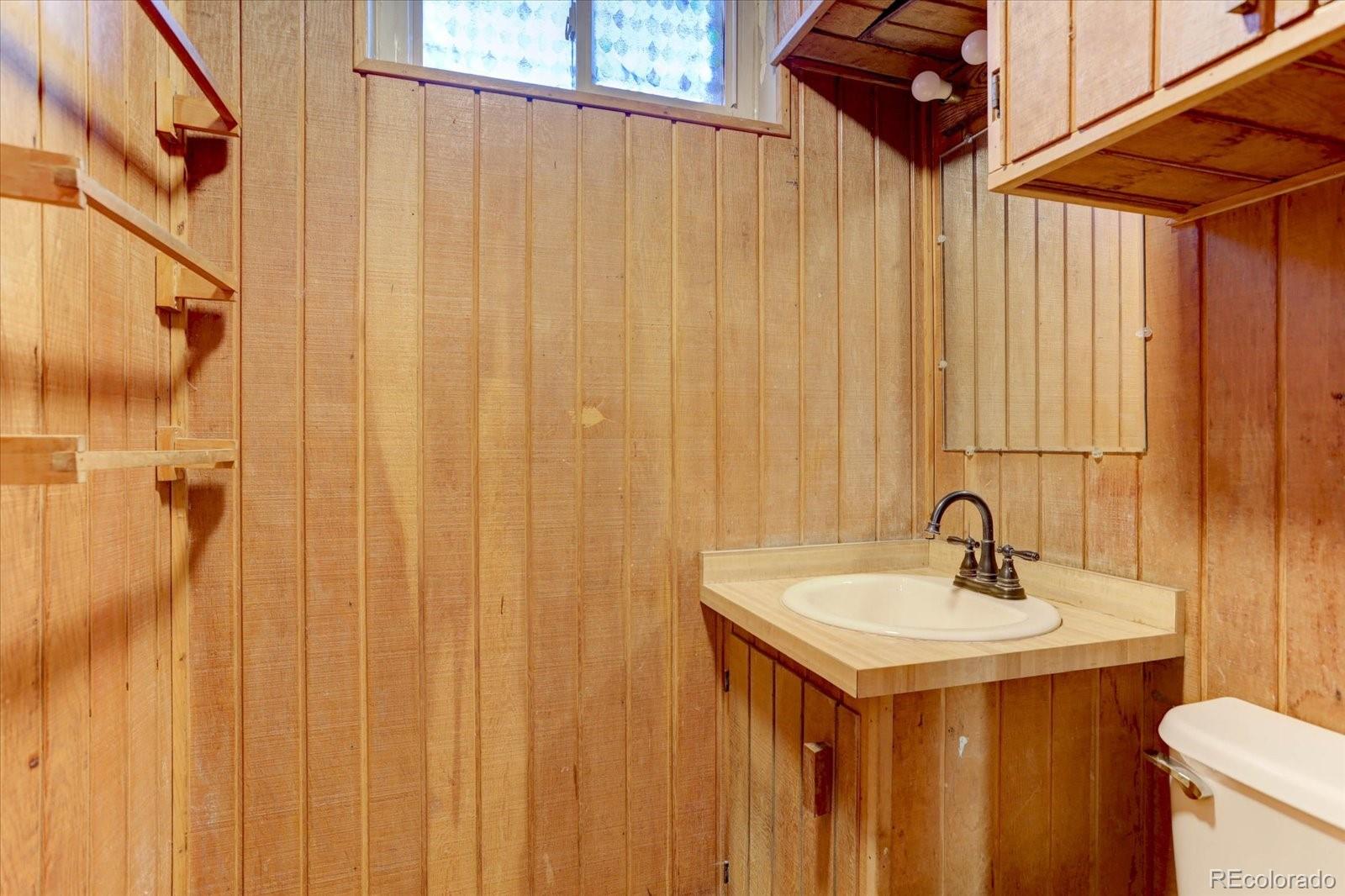 7141 Raritan Street Denver, CO 80221 - Photo 21 of 29 a bathroom with a sink and mirror