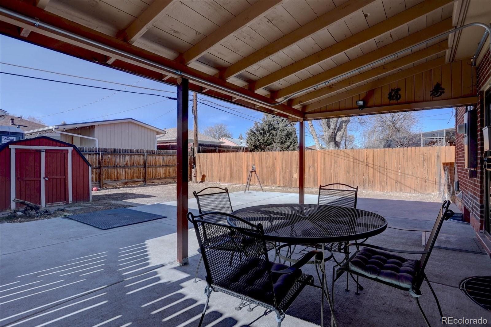 7141 Raritan Street Denver, CO 80221 - Photo 24 of 29 a view of patio with table and chairs and potted plants