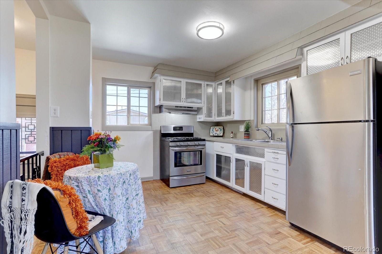 7141 Raritan Street Denver, CO 80221 - Photo 6 of 29 a kitchen with stainless steel appliances granite countertop a refrigerator a stove a sink and a window