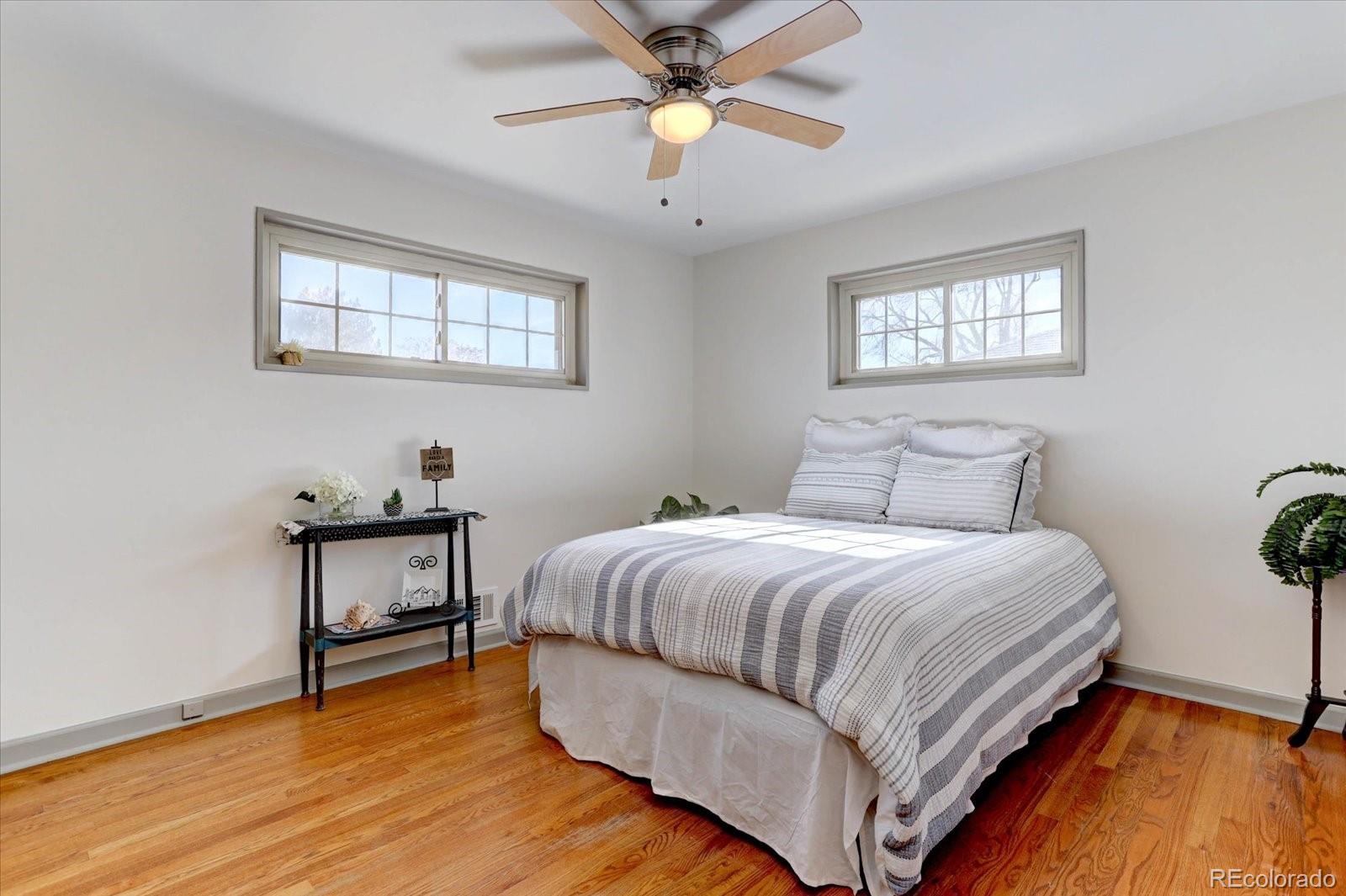 7141 Raritan Street Denver, CO 80221 - Photo 10 of 29 a bedroom with a bed and a chandelier