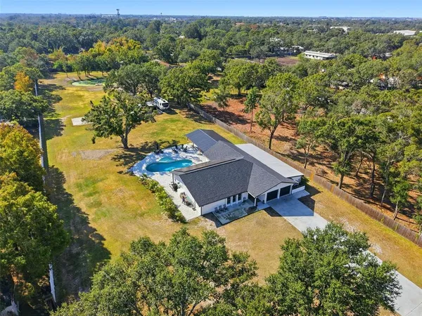 an aerial view of a house with a yard and lake view