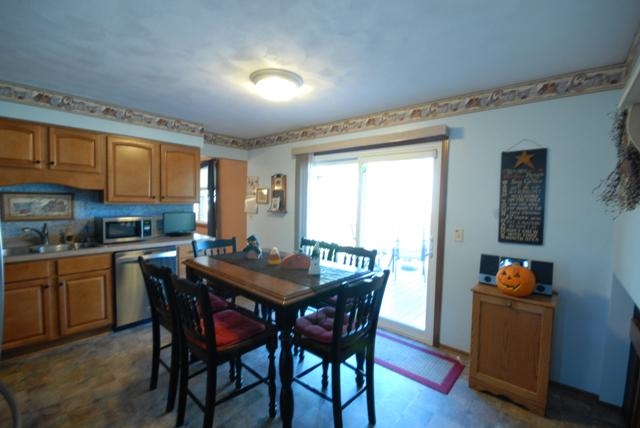 4154 Gloucester Road Roscoe, IL 61073 - Photo 7 of 22 a dining room with a wooden table and chairs