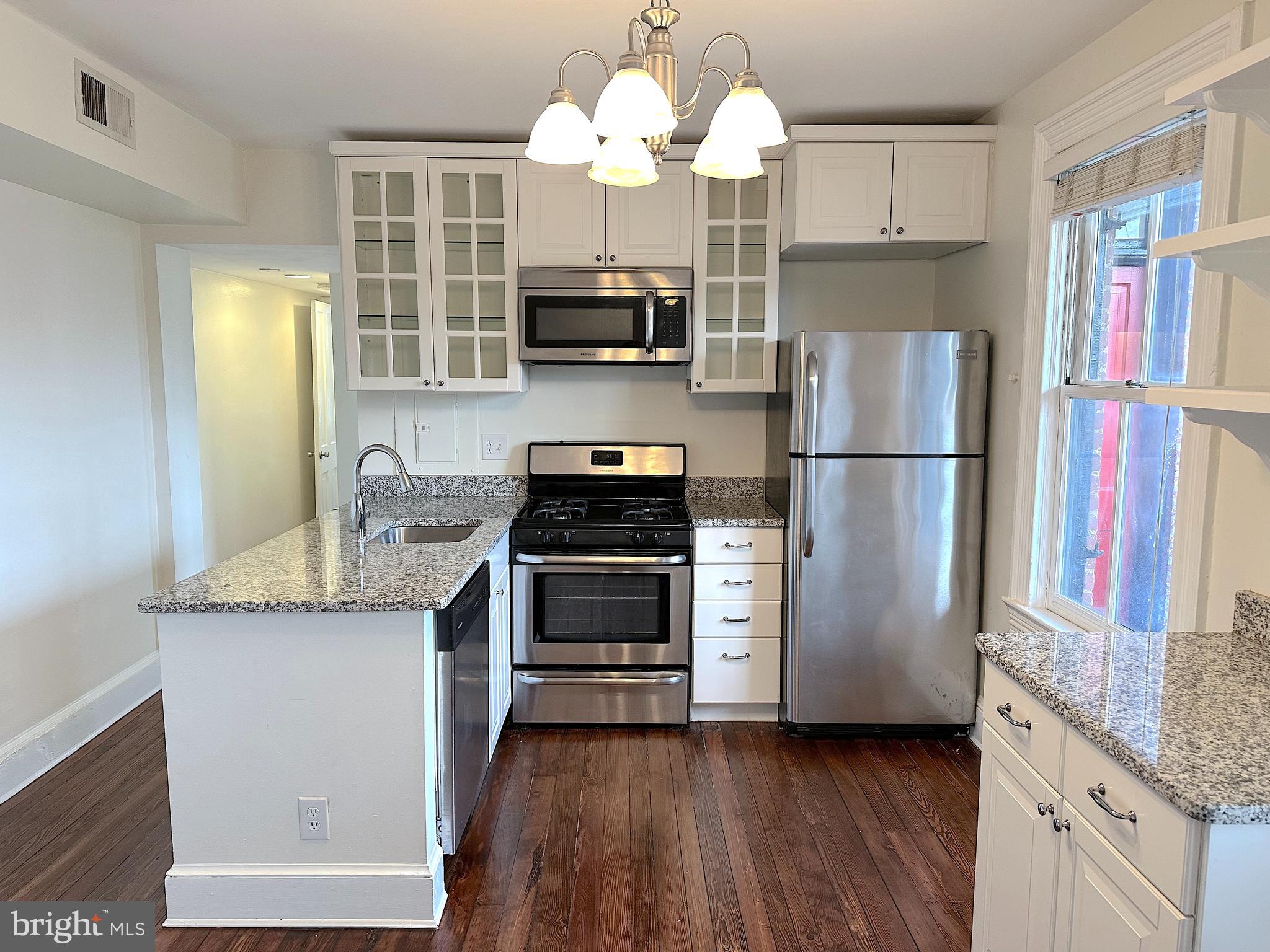 1133 D Street Northeast, Unit 2A Washington, DC 20002 - Photo 2 of 14 a kitchen with stainless steel appliances granite countertop a refrigerator and a stove top oven