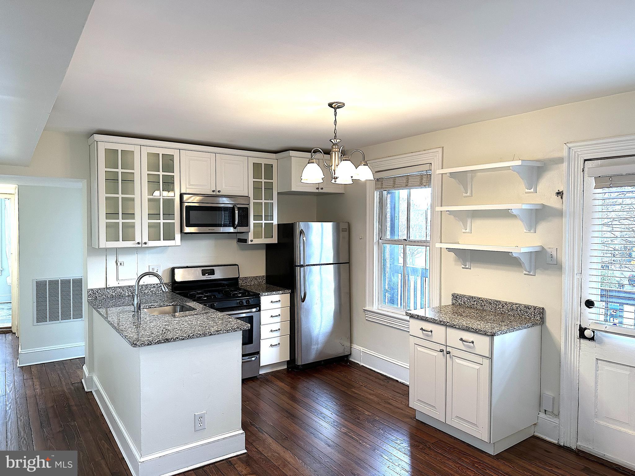 1133 D Street Northeast, Unit 2A Washington, DC 20002 - Photo 3 of 14 a kitchen with stainless steel appliances granite countertop a stove refrigerator and microwave