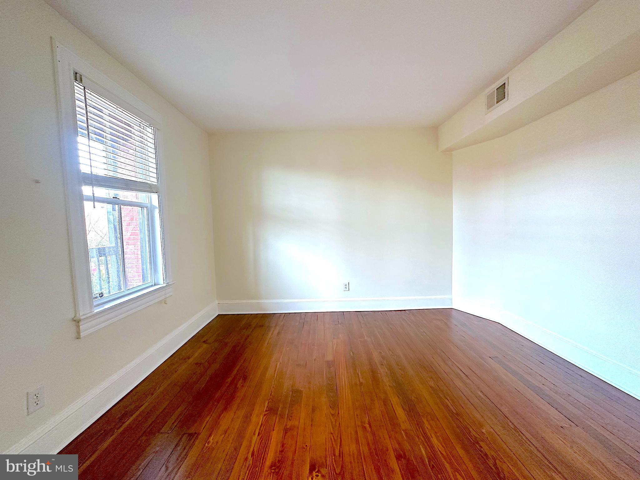 1133 D Street Northeast, Unit 2A Washington, DC 20002 - Photo 7 of 14 a view of an empty room with wooden floor and a window