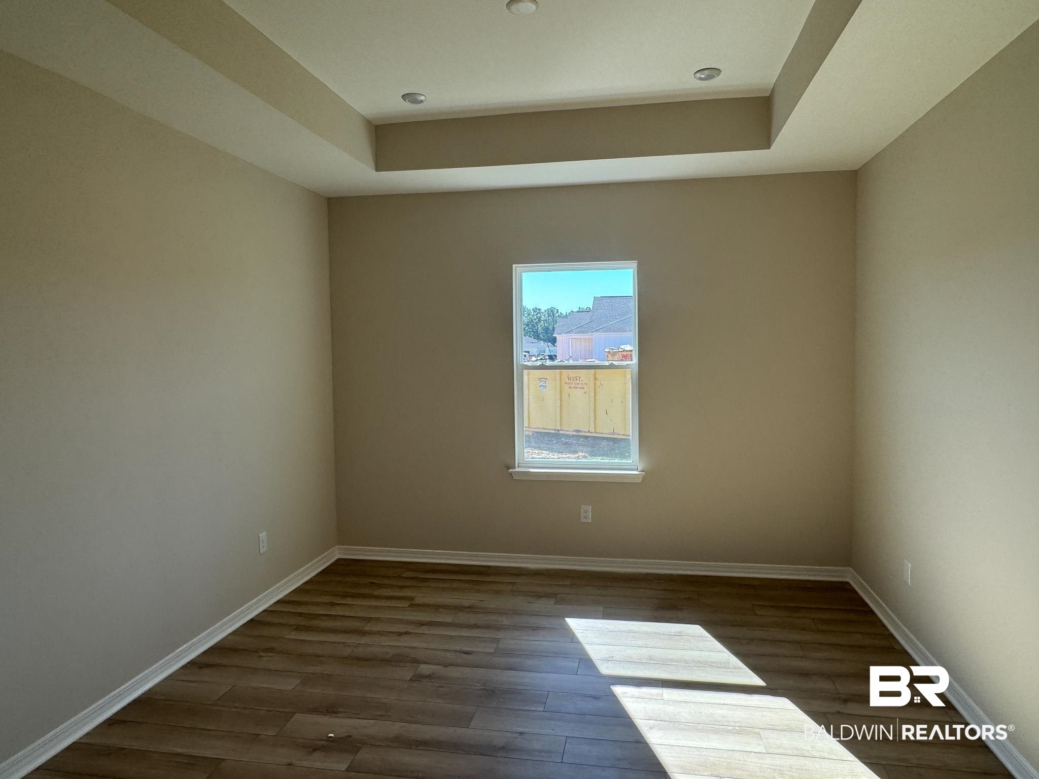 24026 Shadowridge Drive Daphne, AL 36526 - Photo 10 of 11 Spare room featuring dark hardwood / wood-style flooring and a tray ceiling