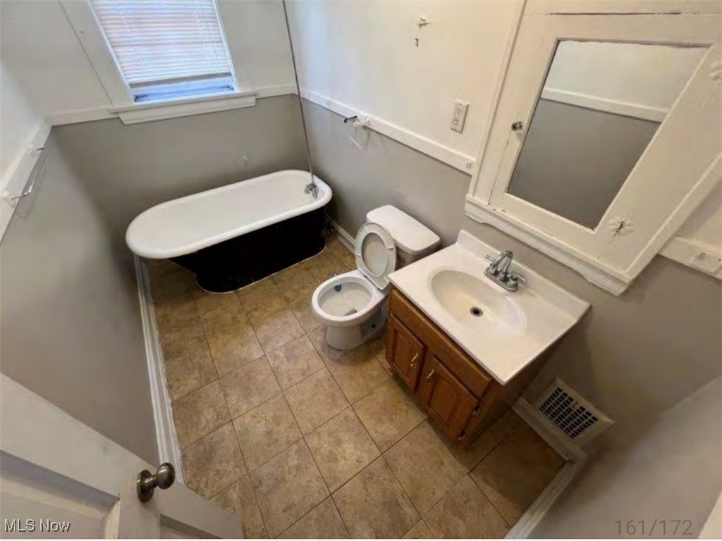 3579 Riedham Road Cleveland, OH 44120 - Photo 13 of 13 Bathroom featuring a tub to relax in, vanity, toilet, and tile patterned flooring