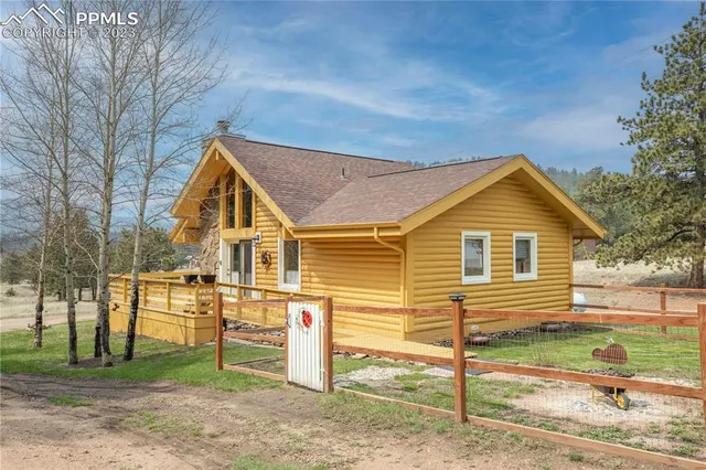 a view of a house with a yard and large tree