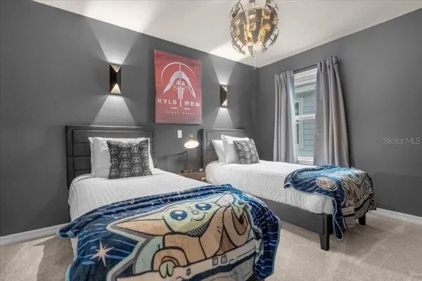 a bedroom with two beds and painting on the wall