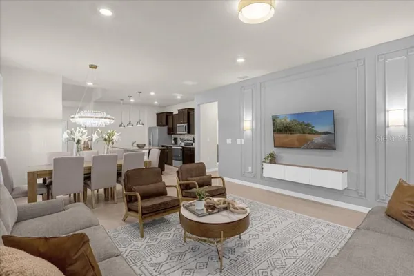 a living room with furniture and a view of kitchen
