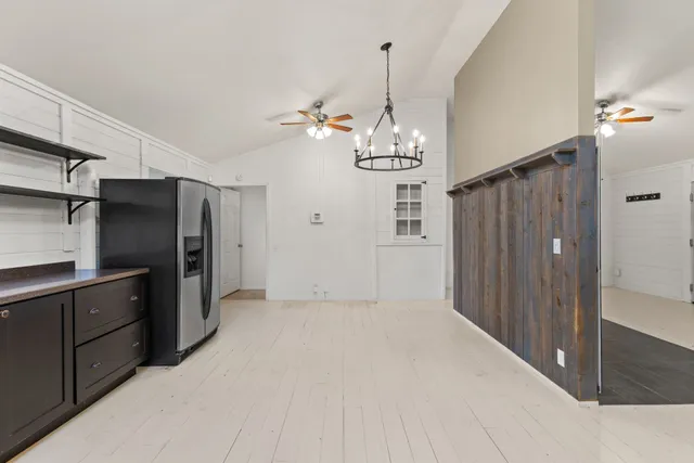 a view of a kitchen with refrigerator and cabinets