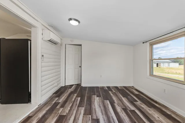 a view of a room with wooden floor and window