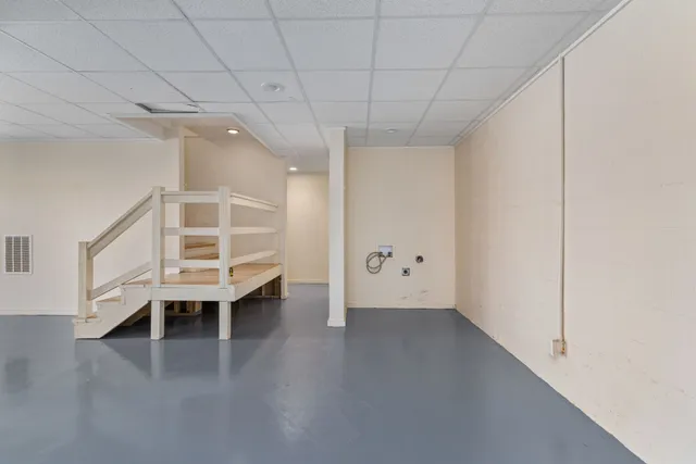 an empty room with ceiling fan and window