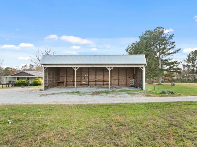 a front view of house with yard and trees in the background