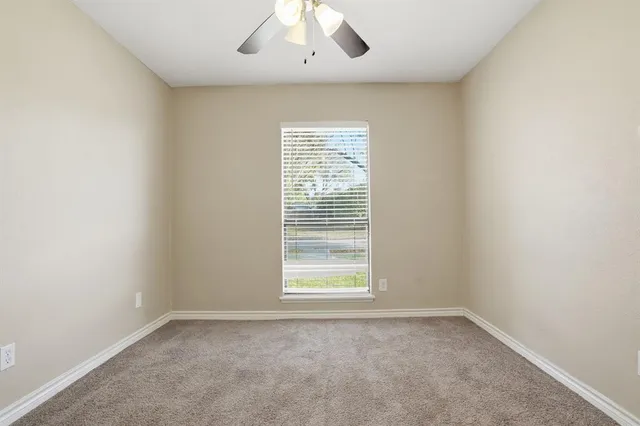an empty room with closet and windows
