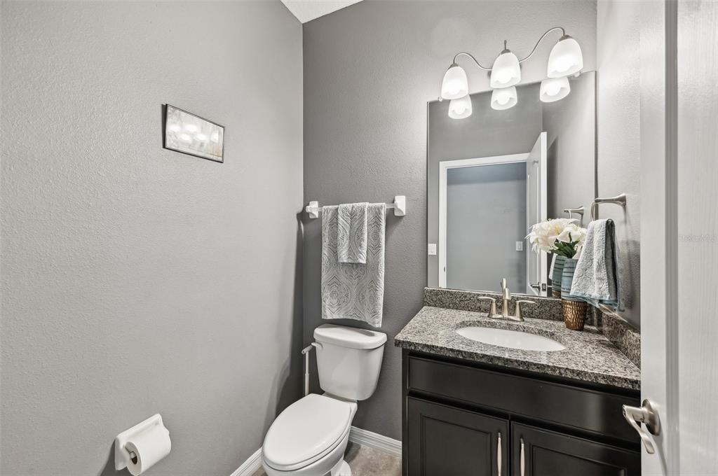 4515 Bent Tree Boulevard Sarasota, FL 34241 - Photo 12 of 34 a bathroom with a granite countertop toilet sink and mirror