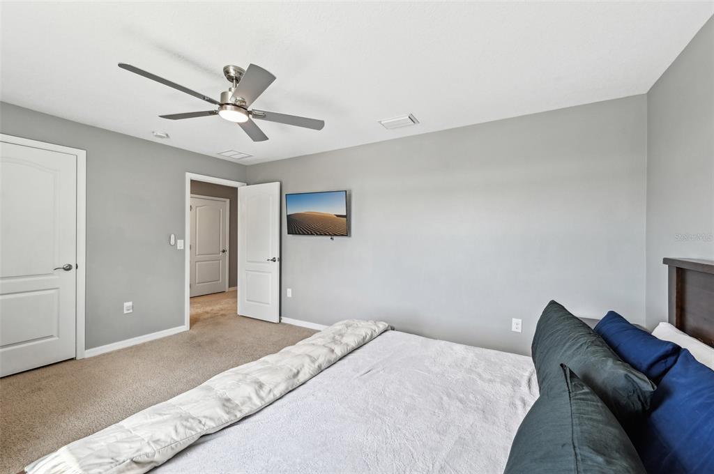 4515 Bent Tree Boulevard Sarasota, FL 34241 - Photo 22 of 34 a bedroom with a bed and a chandelier