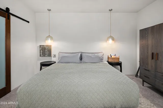 a bedroom with two beds and painting on the wall