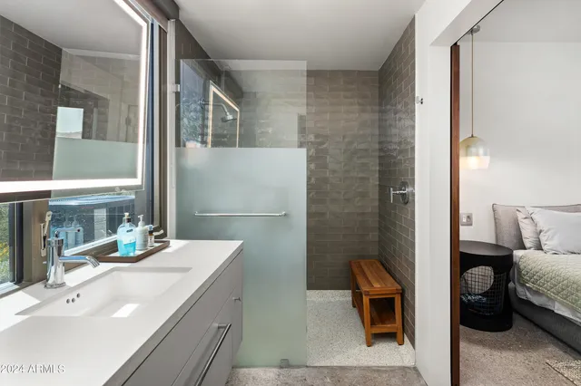 a bedroom with a bed a large window and a couch