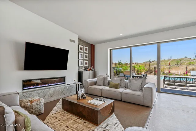 a living room with stainless steel appliances kitchen island furniture and a large window