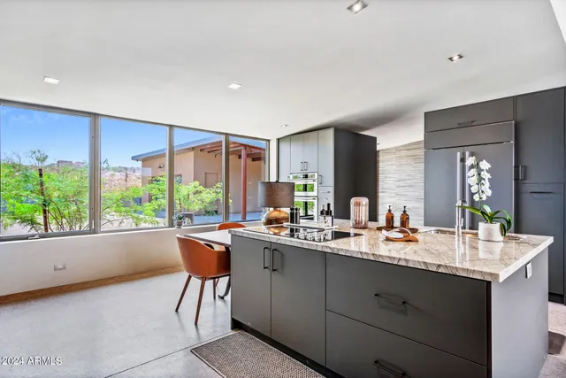 a kitchen with kitchen island granite countertop a sink a counter top space and living room view