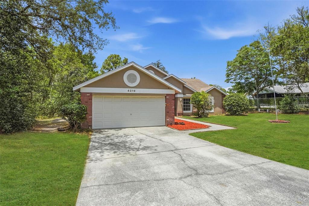 4219 Newton Road Spring Hill, FL 34606 - Photo 3 of 35 a front view of a house with a yard and garage