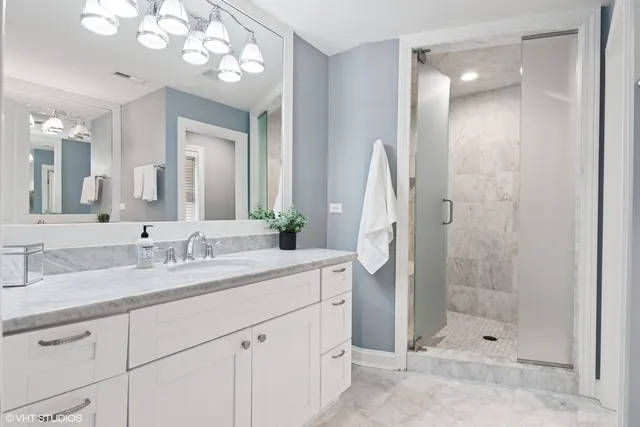 a bathroom with a granite countertop sink toilet and mirror