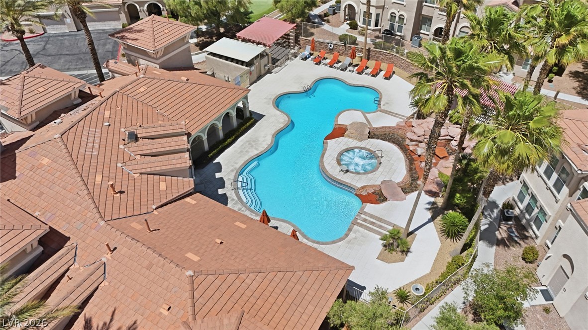 10550 West Alexander Road, Unit 2177 Las Vegas, NV 89129 - Photo 17 of 19 An aerial view showcases a free-form pool and spa, framed by tropical landscaping and architectural charm.