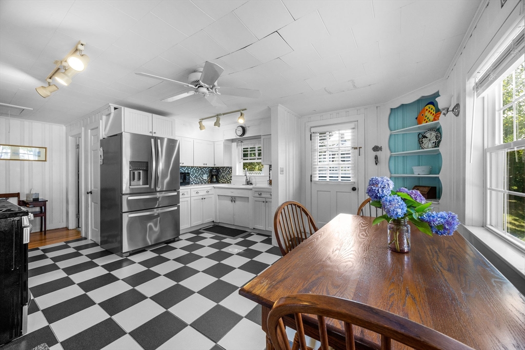 7 Spruce Drive Bourne, MA 02559 - Photo 15 of 39 a kitchen with stainless steel appliances kitchen island granite countertop a refrigerator a sink a stove a dining table and chairs