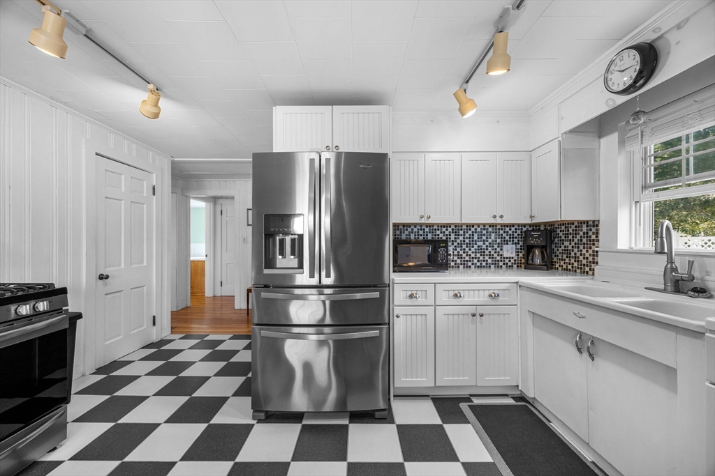 7 Spruce Drive Bourne, MA 02559 - Photo 16 of 39 a kitchen with a checkered floor and white cabinets