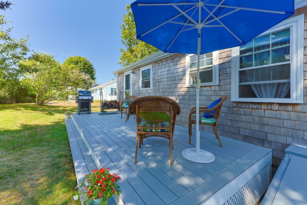 7 Spruce Drive Bourne, MA 02559 - Photo 25 of 39 a patio with a table and chairs under an umbrella