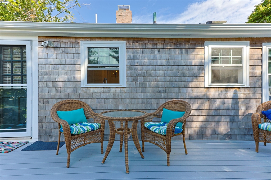 7 Spruce Drive Bourne, MA 02559 - Photo 26 of 39 a front view of a house with table and chairs
