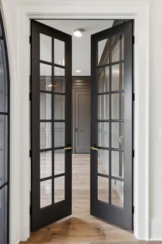 an empty room with wooden floor fireplace and windows
