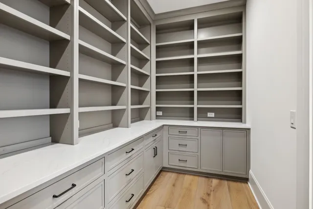 a view of an empty room with wooden floor and windows