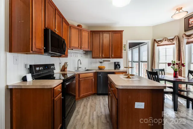 a kitchen with stainless steel appliances granite countertop a sink stove refrigerator and cabinets