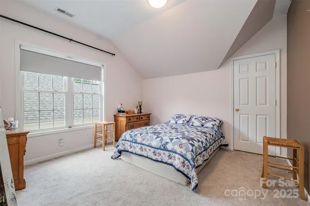 a spacious bedroom with a bed and a window