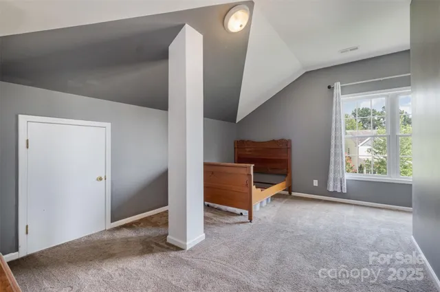a view of an empty room with furniture and a window
